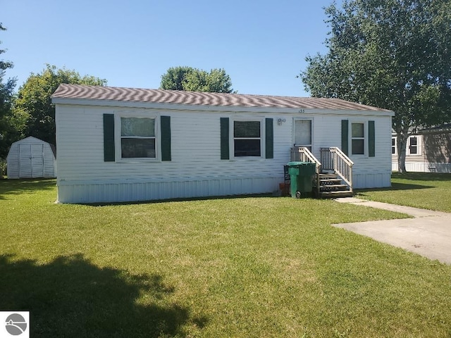 manufactured / mobile home featuring a storage unit and a front lawn