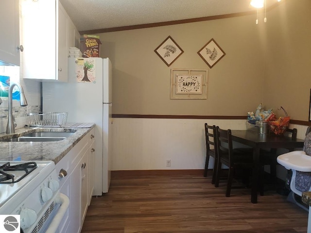 kitchen featuring a textured ceiling, sink, dark hardwood / wood-style floors, white cabinetry, and white gas stove