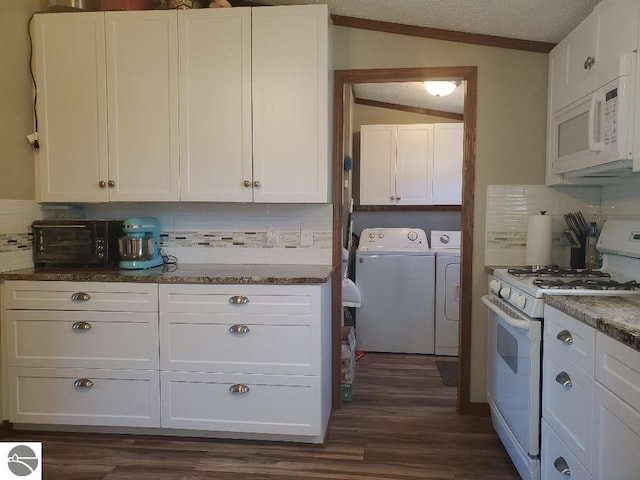 kitchen featuring decorative backsplash, white appliances, vaulted ceiling, washer and clothes dryer, and white cabinetry