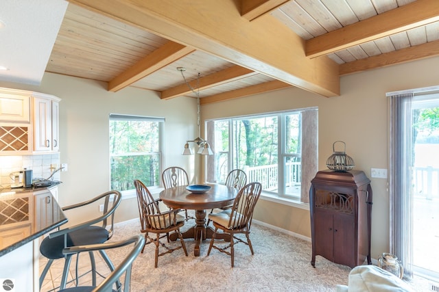 carpeted dining room with beam ceiling and plenty of natural light