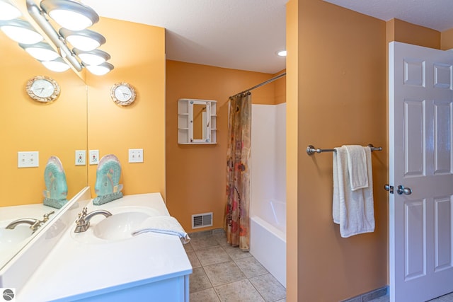 bathroom with tile patterned flooring, vanity, and shower / bath combo