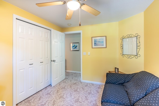 sitting room with ceiling fan and light colored carpet