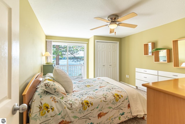 bedroom with ceiling fan, a textured ceiling, access to outside, and a closet