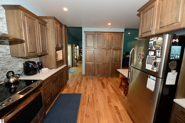 kitchen featuring tasteful backsplash, electric range, custom range hood, light hardwood / wood-style floors, and stainless steel refrigerator