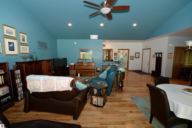 living room with light hardwood / wood-style floors, high vaulted ceiling, and ceiling fan