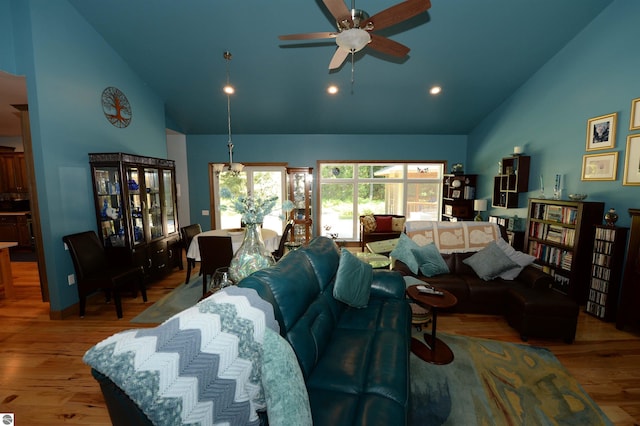 living room with hardwood / wood-style floors, high vaulted ceiling, and ceiling fan