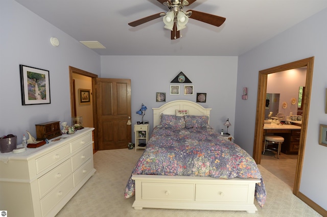 bedroom featuring ensuite bathroom, light carpet, and ceiling fan