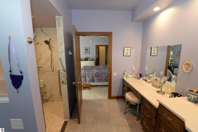 bathroom with vanity, tile patterned flooring, and a tile shower