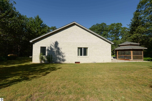 view of property exterior with a gazebo and a lawn