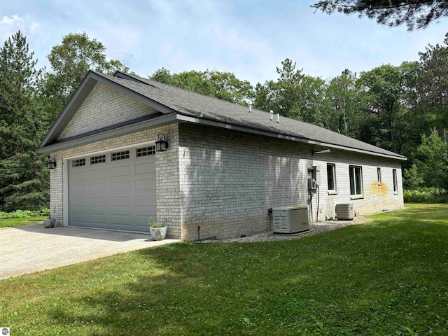 view of side of property with central AC unit and a yard