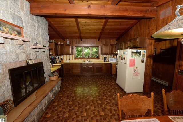 kitchen featuring a fireplace, vaulted ceiling with beams, wooden ceiling, white appliances, and a baseboard radiator