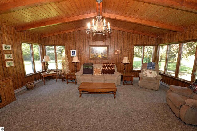 carpeted living room featuring vaulted ceiling with beams, wooden walls, and wooden ceiling