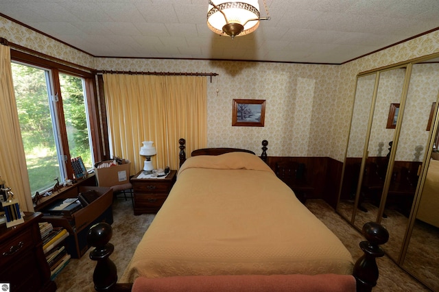 bedroom with dark colored carpet, a closet, and crown molding