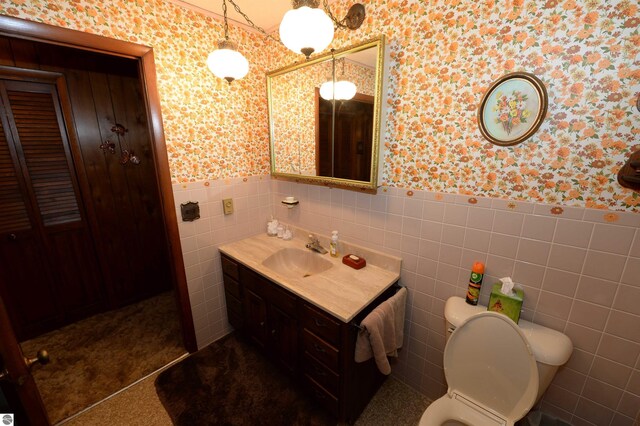 bathroom with vanity, decorative backsplash, tile walls, and toilet