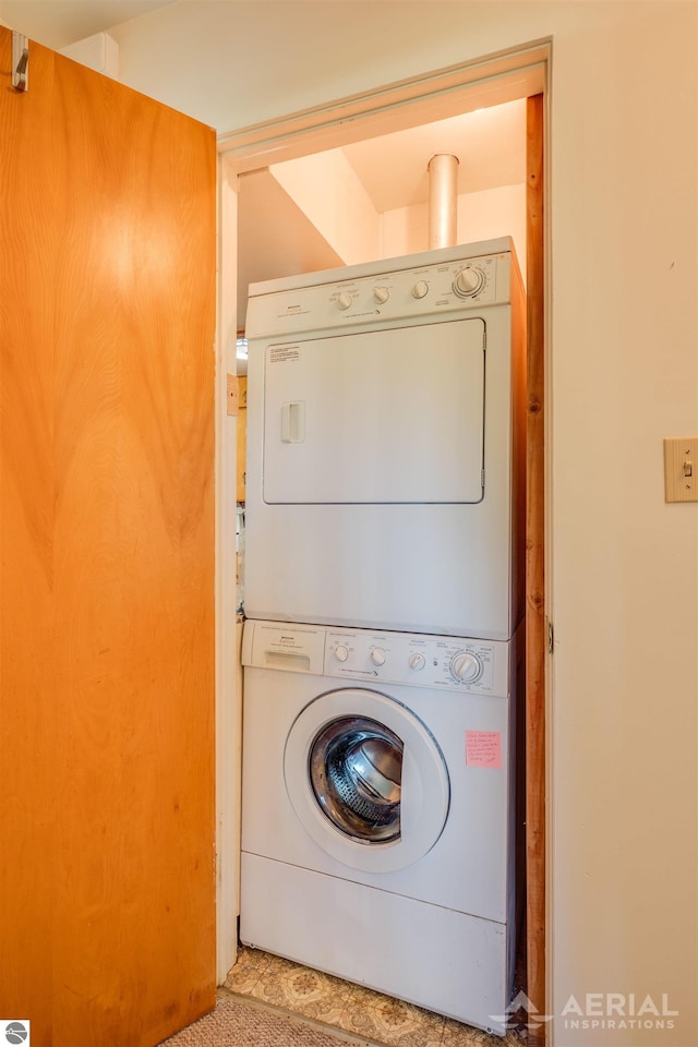 laundry area featuring tile patterned floors and stacked washer / drying machine