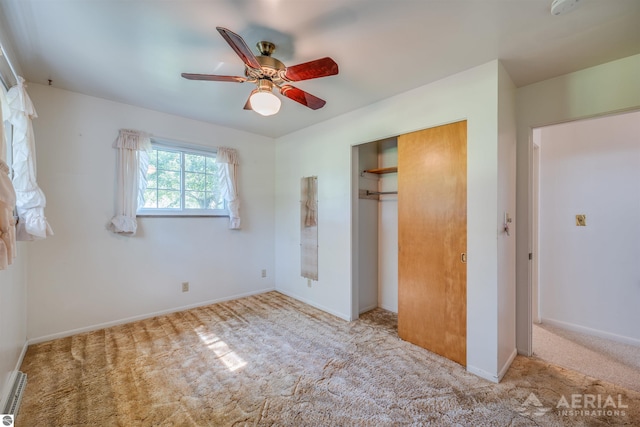 unfurnished bedroom featuring ceiling fan, a closet, and light colored carpet