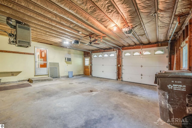 garage with a garage door opener and an AC wall unit