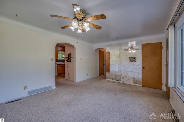 empty room with ceiling fan and light carpet