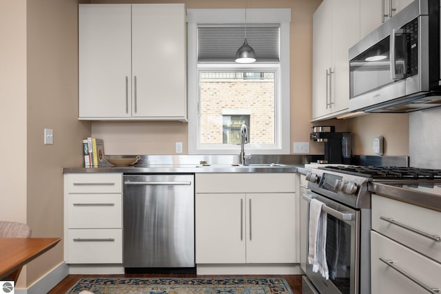 kitchen with sink, stainless steel counters, stainless steel appliances, and white cabinets