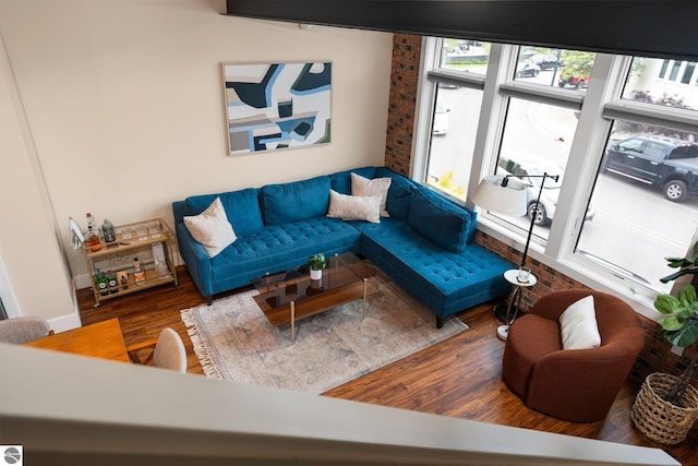 living room featuring brick wall and dark hardwood / wood-style floors