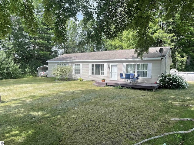 back of property featuring a deck and a lawn