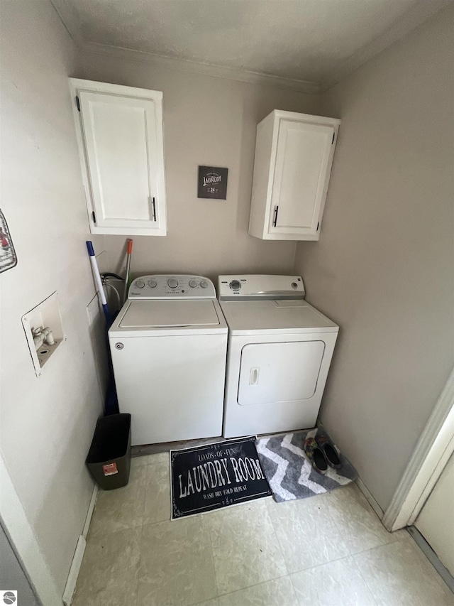 clothes washing area featuring cabinets and washing machine and dryer