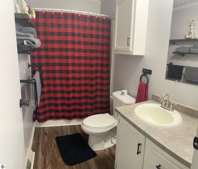 bathroom with toilet, vanity, wood-type flooring, and ornamental molding