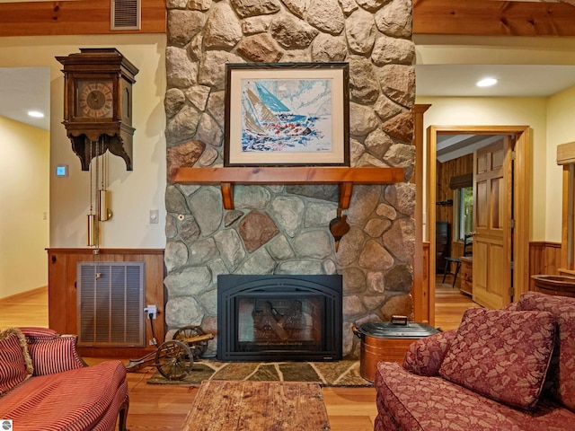 living room featuring wood walls, a fireplace, and wood-type flooring