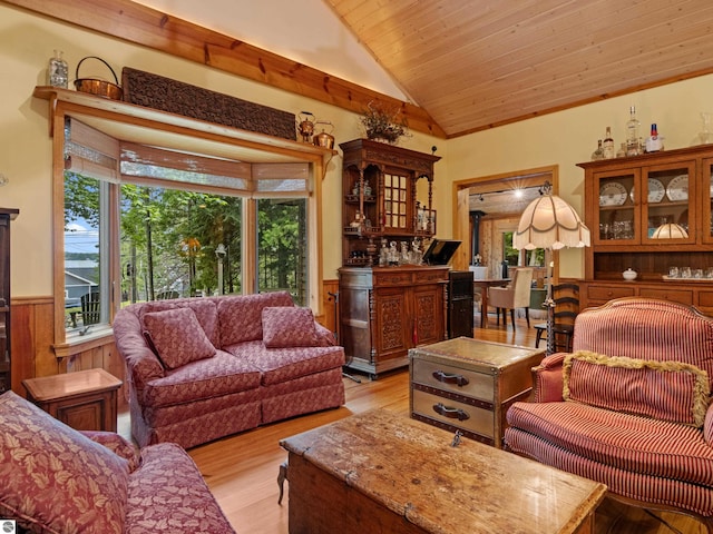 living room featuring wood ceiling, wooden walls, high vaulted ceiling, light hardwood / wood-style flooring, and bar area