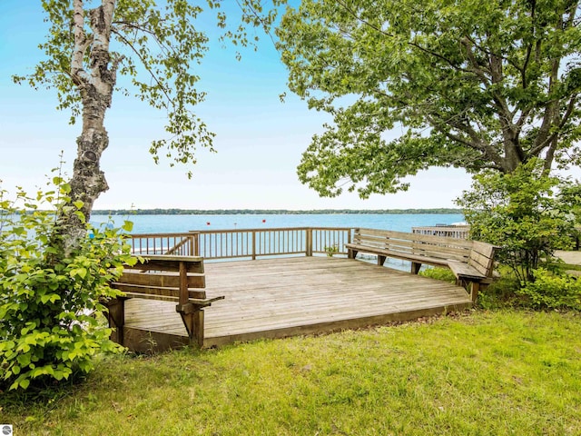 dock area featuring a yard and a deck with water view