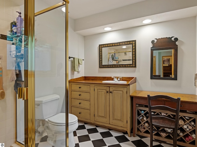 bathroom with vanity, toilet, and a shower with door