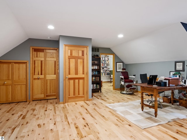 home office with light hardwood / wood-style floors and lofted ceiling