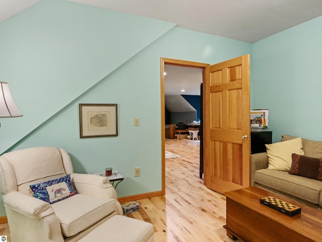 living area featuring vaulted ceiling and light hardwood / wood-style flooring