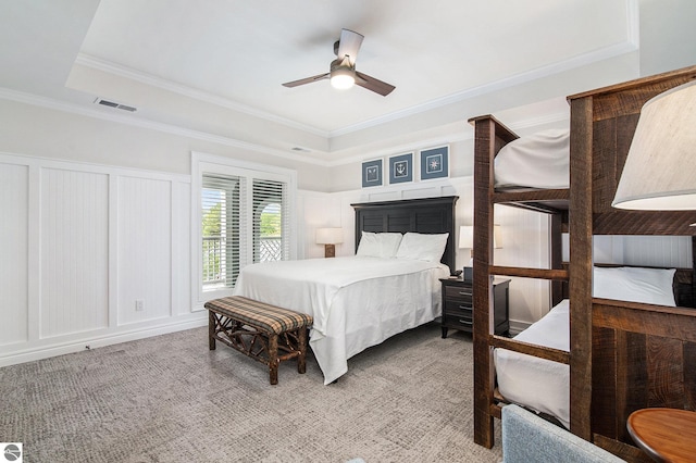 bedroom with ceiling fan, carpet, crown molding, and a tray ceiling