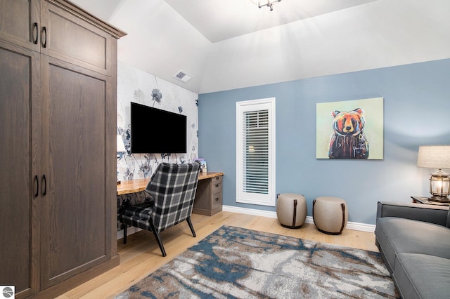 office area with light hardwood / wood-style flooring and vaulted ceiling