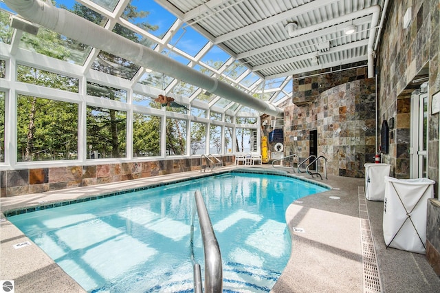 view of swimming pool with glass enclosure and a patio area