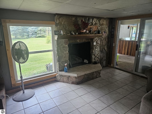 living room with tile patterned floors, a drop ceiling, and a fireplace