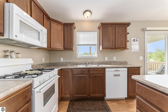 kitchen featuring sink, white appliances, and light wood-type flooring