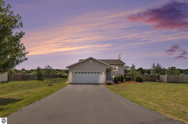 view of front of home with a garage and a yard