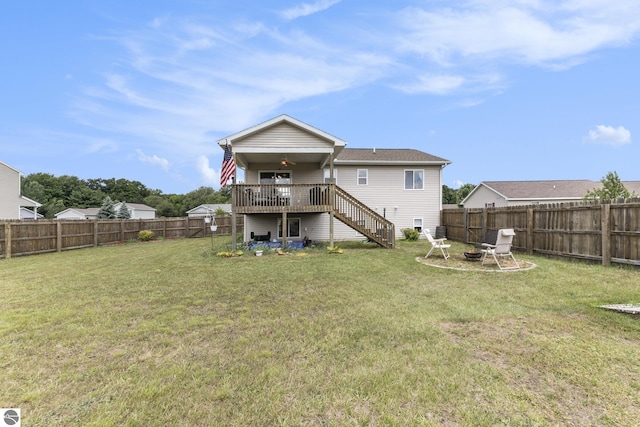 back of house with a yard, a deck, and an outdoor fire pit