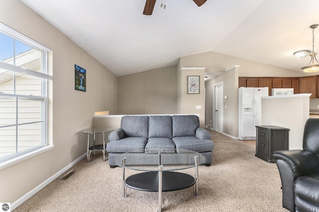 living room with lofted ceiling, light colored carpet, and ceiling fan