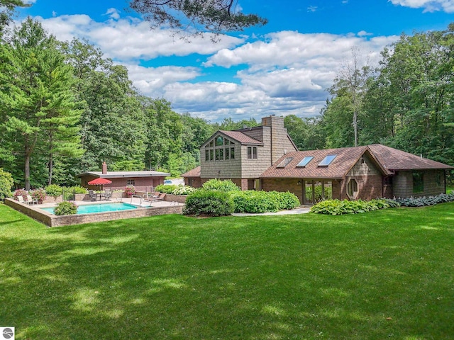 rear view of house featuring a patio and a lawn