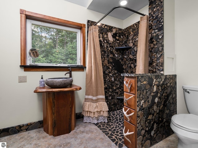 bathroom with a shower with curtain, toilet, and sink