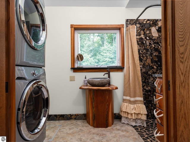 washroom featuring stacked washing maching and dryer and sink