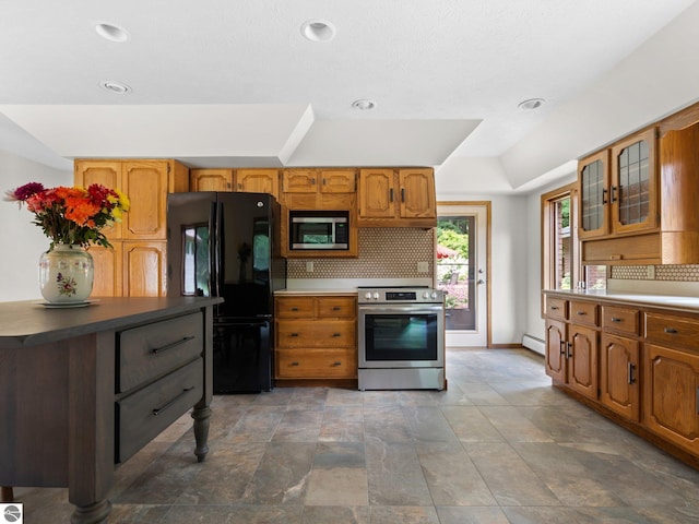 kitchen with decorative backsplash, stainless steel appliances, and a baseboard radiator