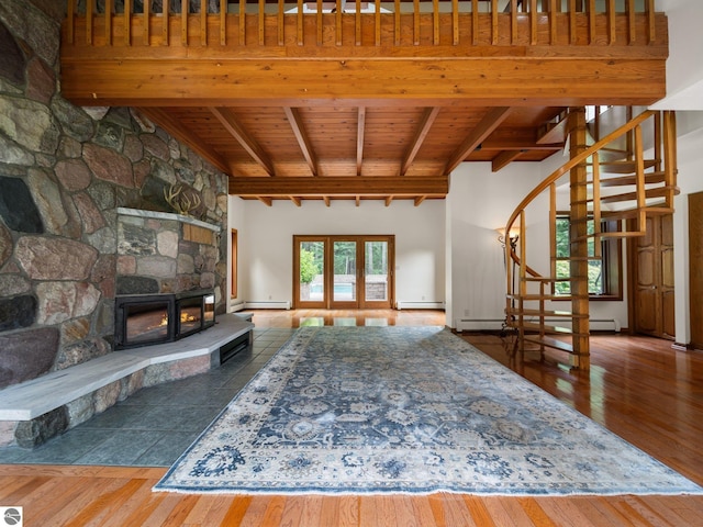 unfurnished living room with beamed ceiling, dark hardwood / wood-style flooring, baseboard heating, and wooden ceiling