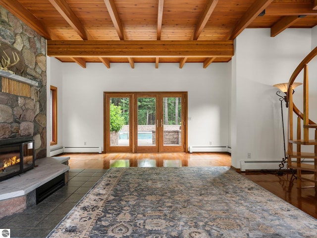 unfurnished living room featuring beam ceiling, a baseboard heating unit, and wooden ceiling