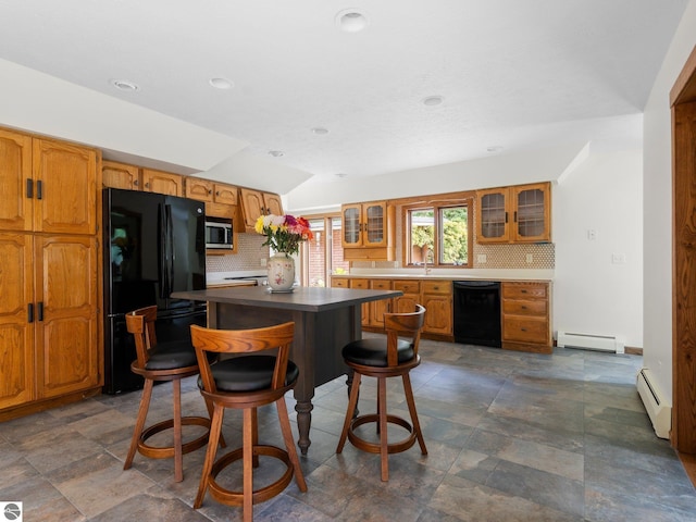 kitchen featuring backsplash, a center island, black appliances, and baseboard heating