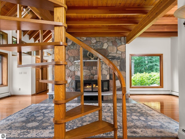 stairway featuring a wealth of natural light, a fireplace, beamed ceiling, and wooden ceiling