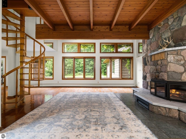 unfurnished living room featuring a fireplace, a high ceiling, beamed ceiling, and wood ceiling